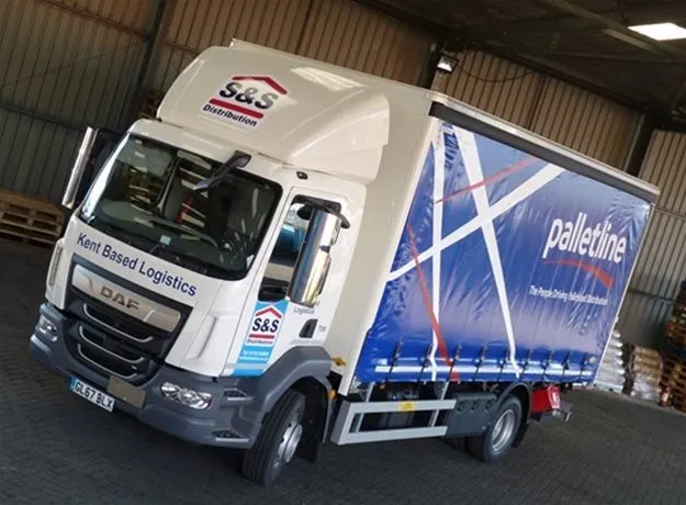S&S Distribution lorry parked inside a warehouse, featuring “Kent Based Logistics” on the cab and a Palletline branded curtain side trailer.